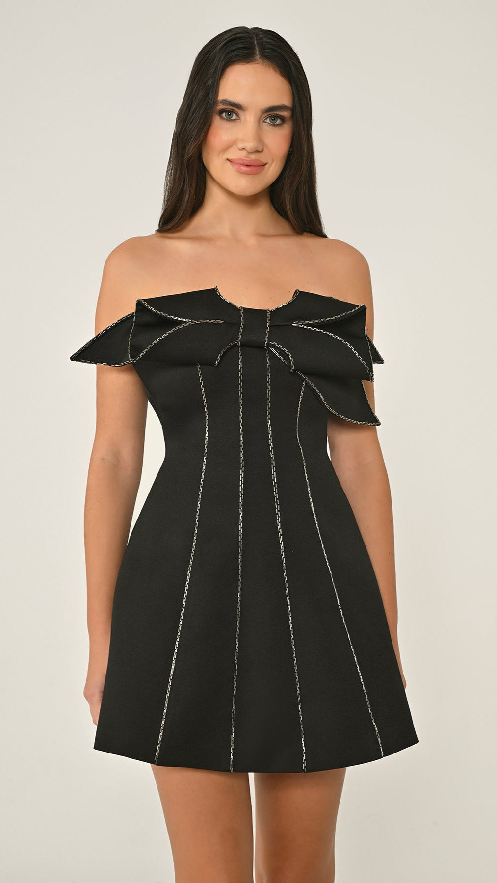 Black off-shoulder dress with white stitching on a plain background