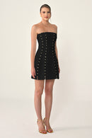 Black strapless dress with button details on a white background