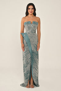 Woman wearing a strapless dress with teal accents on a beige background