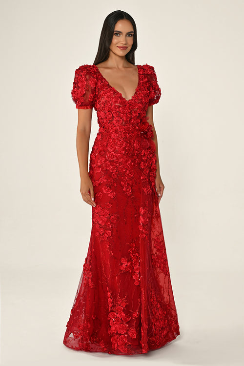 Woman wearing a red floral evening gown on a white background