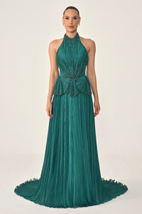 Woman wearing a green evening gown with a plain background