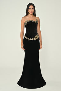 Black strapless evening gown with gold embellishments on a neutral background