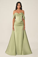 Woman wearing a green strapless gown on a beige background