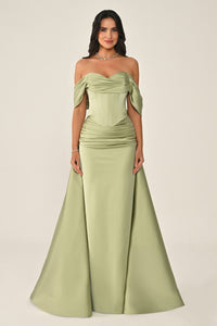 Woman wearing a green strapless gown on a beige background