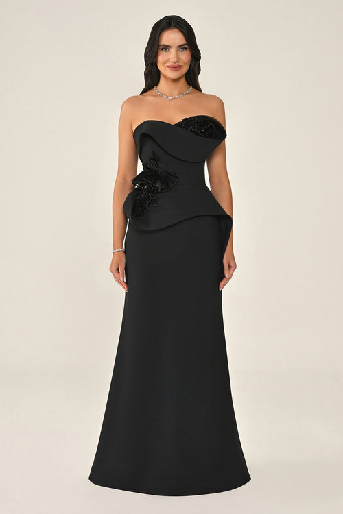 Black strapless gown with floral details on a beige background