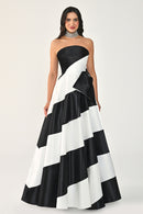 Woman wearing a black and white striped strapless gown on a white background