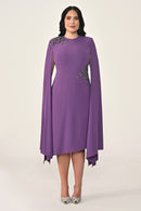 Woman wearing a purple dress with embellishments on a white background