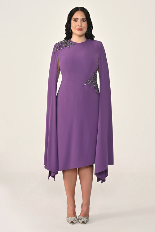Woman wearing a purple dress with embellishments on a white background