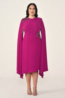 Woman wearing a pink dress with embellishments on a white background
