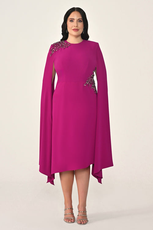 Woman wearing a pink dress with embellishments on a white background
