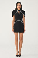 Woman wearing a black dress with white trim on a white background