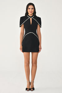 Woman wearing a black dress with white trim on a white background