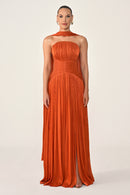 Woman wearing an orange halter neck gown on a white background