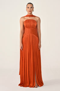 Woman wearing an orange halter neck gown on a white background