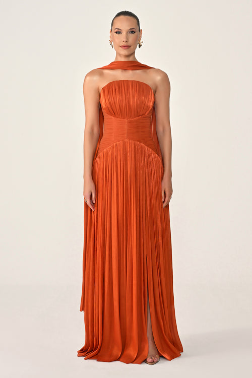 Woman wearing an orange halter neck gown on a white background