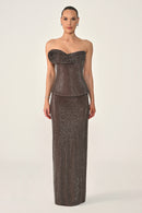 Woman wearing a strapless, sequined evening gown on a white background