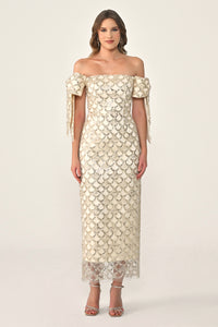 Woman wearing a beige off-shoulder lace dress on a white background