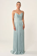Woman wearing a light blue strapless gown on a white background