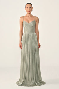 Woman wearing a long, light green dress on a white background