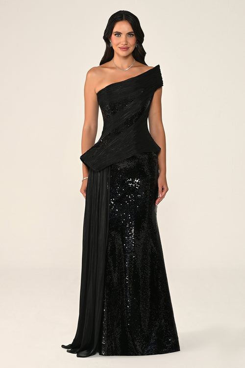 Woman wearing a black one-shoulder evening gown with sequin details on a beige background