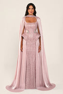 Celestara Dress in Baby Pink: sequin column gown with a square neckline, peplum hip detail, stone-embellished waist and a flowing organza cape