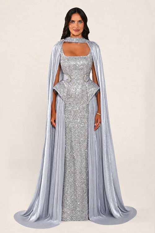 Celestara Dress in Grey: sequin column gown with a square neckline, peplum hip detail, stone-embellished waist and a flowing organza cape