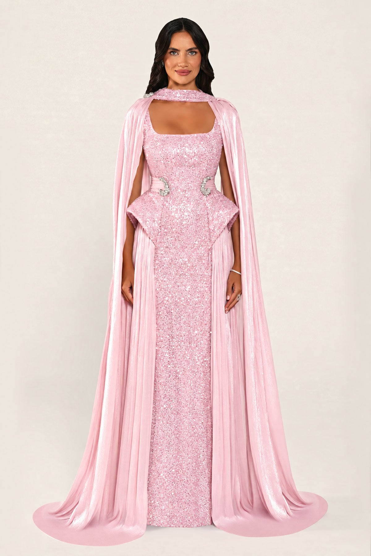 Celestara Dress in Pink: sequin column gown with a square neckline, peplum hip detail, stone-embellished waist and a flowing organza cape