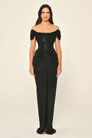 Woman wearing a black off-shoulder gown on a beige background