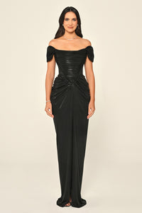 Woman wearing a black off-shoulder gown on a beige background