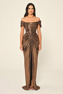 Woman wearing a bronze off-shoulder gown on a beige background