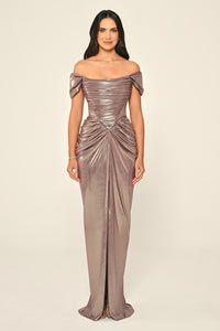 Woman wearing a metallic off-shoulder gown on a beige background