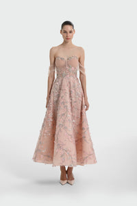 Woman wearing a pink floral off-shoulder dress on a white background