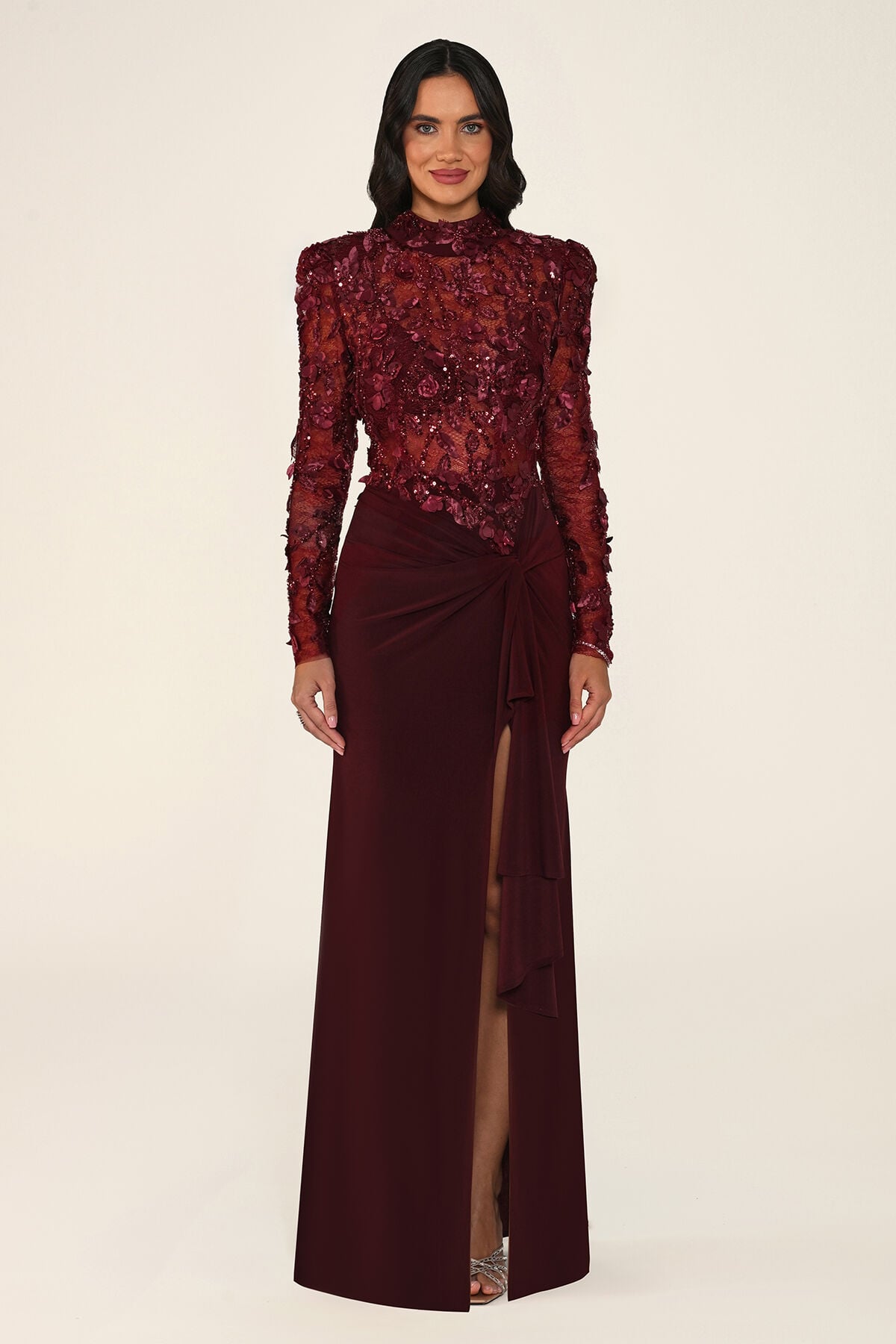 Vespera burgundy maxi evening dress with long sleeves, high neck, sequinned floral lace bodice and tie-waist skirt with leg slit