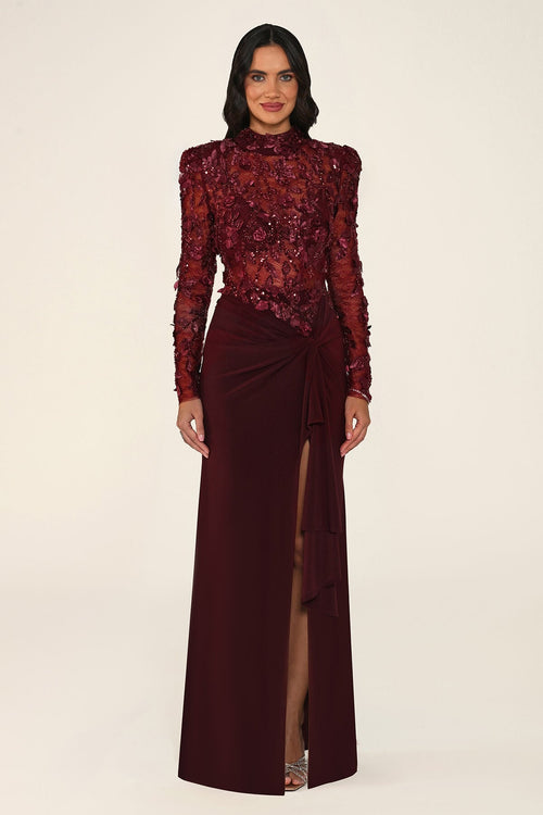 Vespera burgundy maxi evening dress with long sleeves, high neck, sequinned floral lace bodice and tie-waist skirt with leg slit